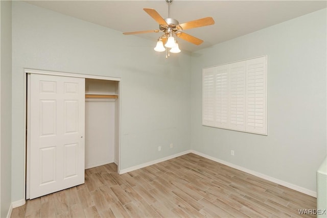 unfurnished bedroom featuring baseboards, a closet, a ceiling fan, and light wood-style floors