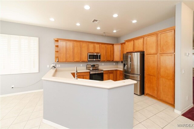 kitchen featuring visible vents, a peninsula, stainless steel appliances, light countertops, and open shelves