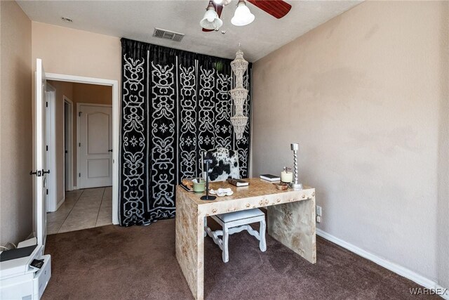 home office featuring ceiling fan, dark tile patterned flooring, visible vents, baseboards, and dark colored carpet