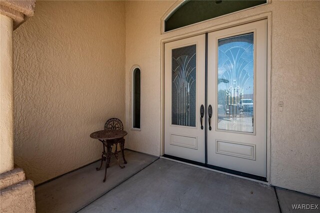 property entrance with french doors and stucco siding