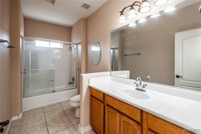 bathroom featuring visible vents, toilet, enclosed tub / shower combo, vanity, and tile patterned flooring