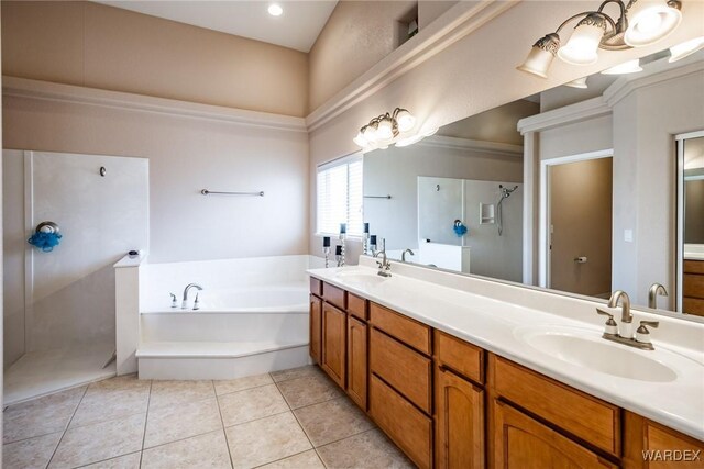 full bath featuring tile patterned flooring, double vanity, a sink, and a bath