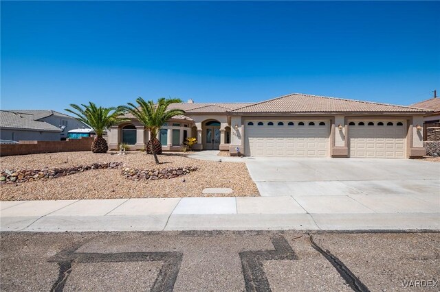 view of front of home with a garage, driveway, a tiled roof, and stucco siding