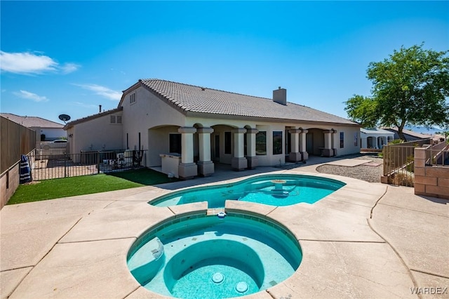 view of swimming pool featuring a patio area, fence, and a pool with connected hot tub