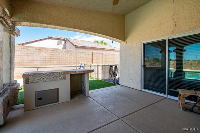 view of patio with exterior kitchen and fence