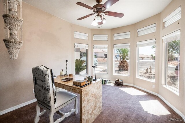 office area with baseboards, dark colored carpet, and a ceiling fan