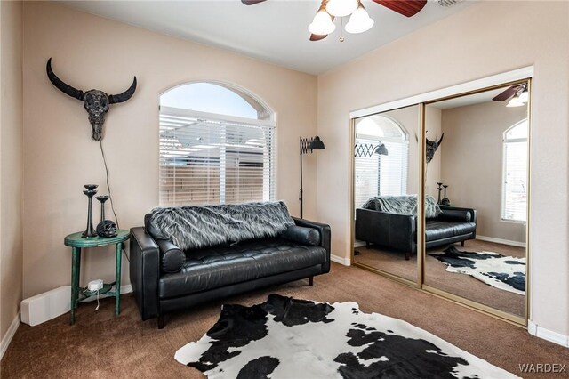 sitting room with carpet, baseboards, and a ceiling fan