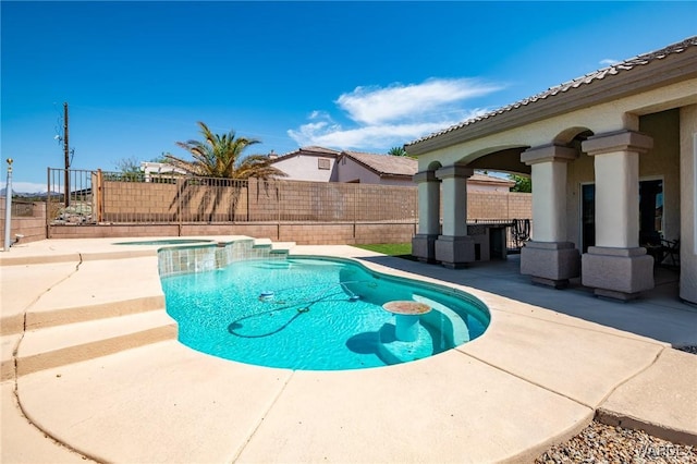 view of swimming pool with a patio, a fenced backyard, and a pool with connected hot tub