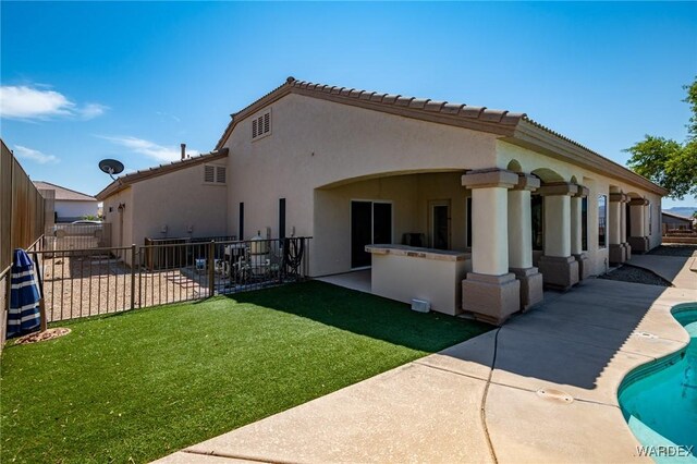 back of house with a fenced in pool, a yard, stucco siding, a patio area, and fence