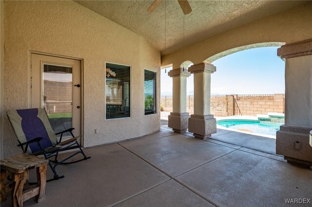 view of patio with a fenced in pool, fence, and ceiling fan