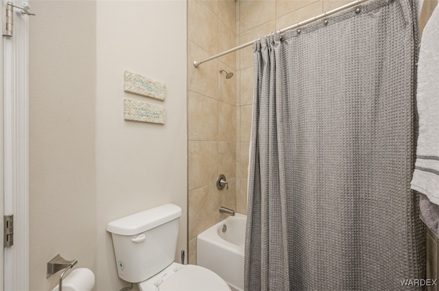 bathroom featuring shower / tub combo and toilet