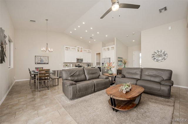 living area with high vaulted ceiling, ceiling fan with notable chandelier, visible vents, and light tile patterned floors