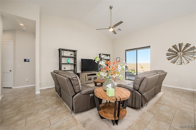 living area featuring lofted ceiling, light tile patterned floors, ceiling fan, and baseboards