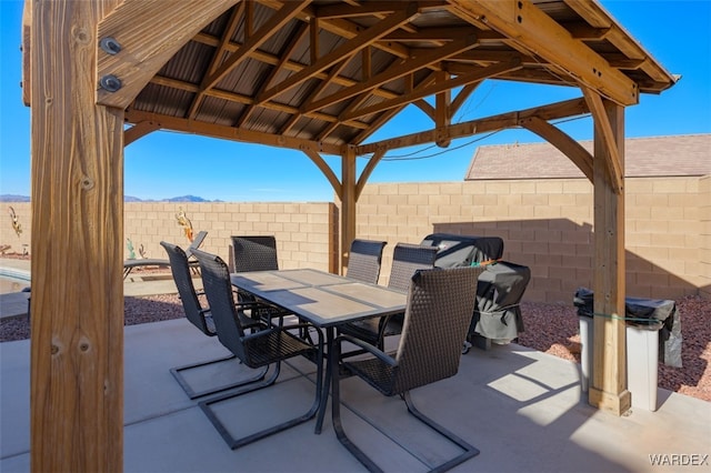 view of patio with a gazebo, outdoor dining area, and a fenced backyard