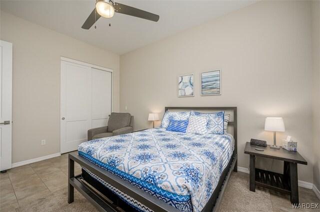 bedroom with a closet, tile patterned flooring, a ceiling fan, and baseboards