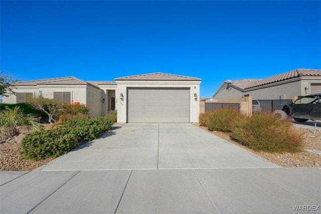 single story home featuring concrete driveway, fence, an attached garage, and stucco siding