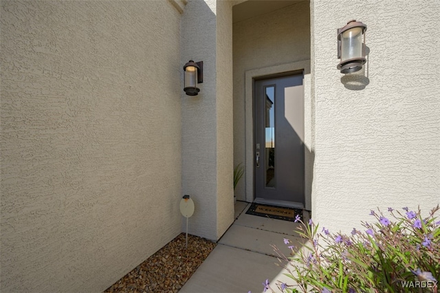 doorway to property featuring stucco siding