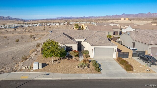 view of front facade with a residential view, a mountain view, driveway, and an attached garage