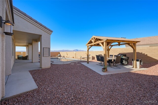 view of yard featuring a patio area, a mountain view, and a fenced backyard