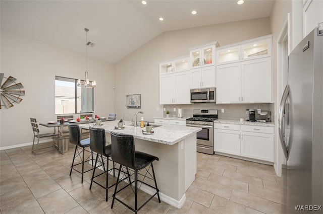 kitchen featuring appliances with stainless steel finishes, a center island with sink, a sink, and white cabinetry