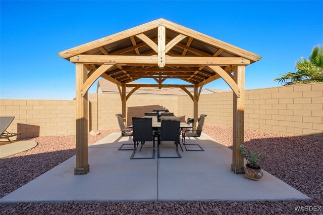 view of patio featuring a gazebo, outdoor dining space, and a fenced backyard