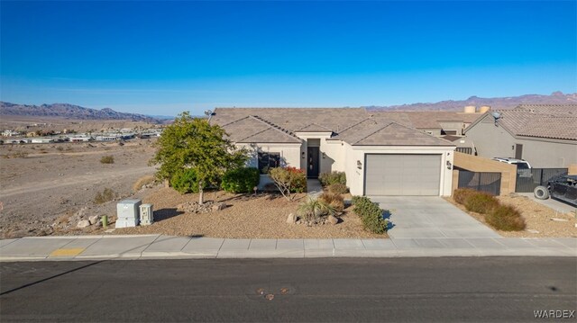 ranch-style house featuring a mountain view, a garage, concrete driveway, a residential view, and stucco siding