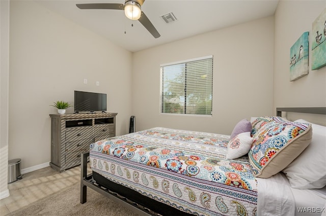 bedroom featuring baseboards, visible vents, a ceiling fan, and light colored carpet