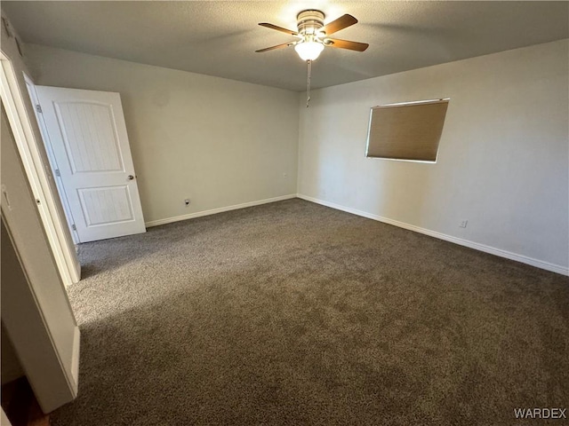 unfurnished room featuring baseboards, dark carpet, ceiling fan, and a textured ceiling