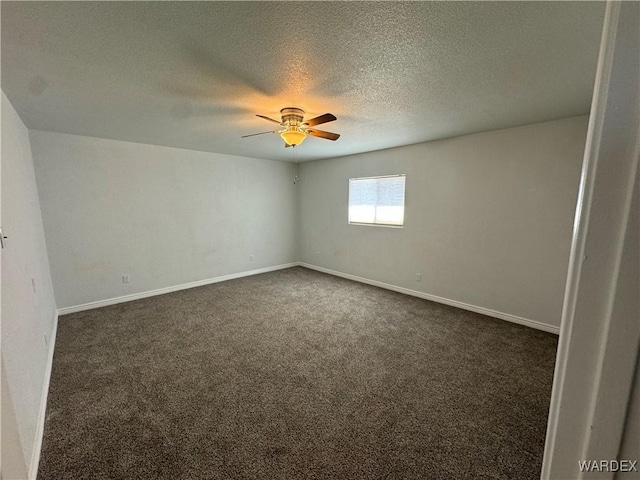 unfurnished room featuring baseboards, dark carpet, ceiling fan, and a textured ceiling