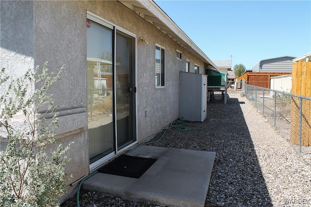 view of side of home with a fenced backyard and stucco siding