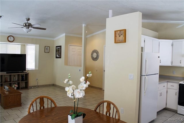 dining space with crown molding, ceiling fan, baseboards, and light tile patterned floors