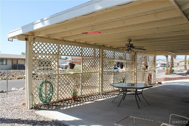 view of patio featuring a ceiling fan, outdoor dining space, and fence