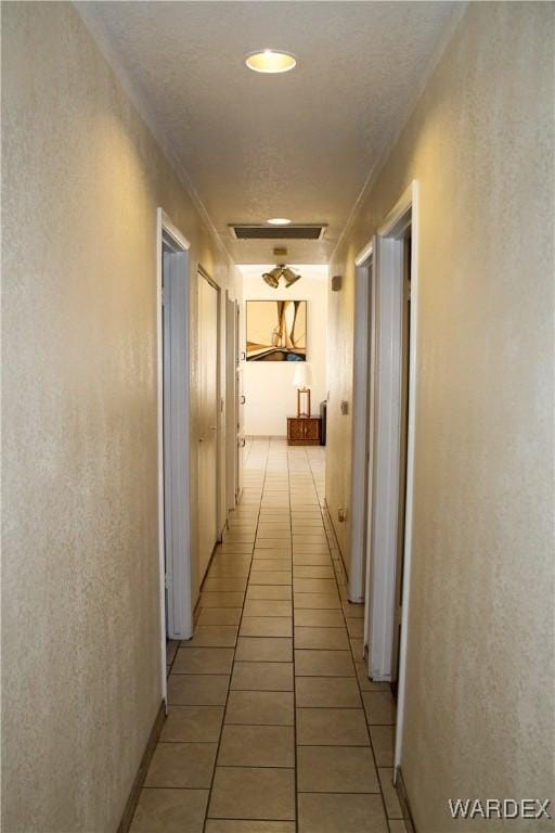 hall with visible vents and light tile patterned floors