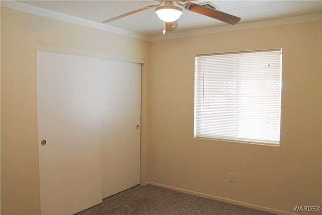 unfurnished bedroom featuring ceiling fan, a closet, carpet, and visible vents