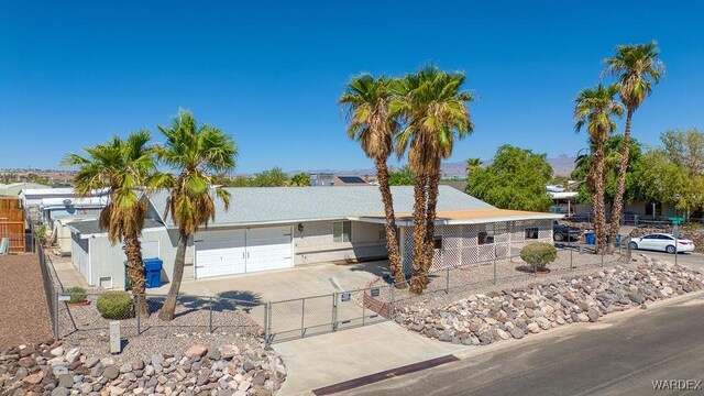 ranch-style home with driveway, an attached garage, fence, and stucco siding