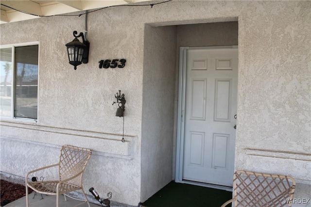 entrance to property featuring stucco siding