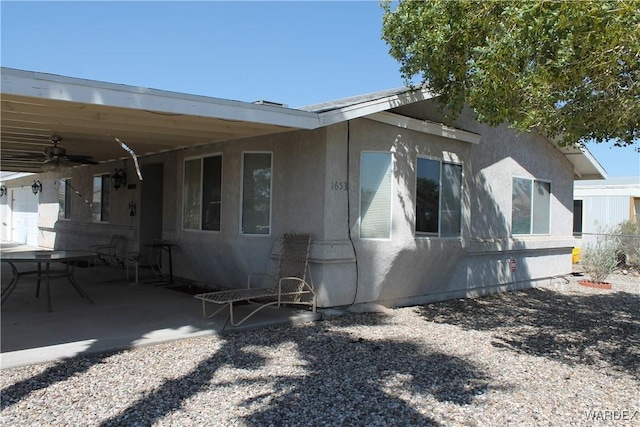 exterior space with a patio area, fence, a ceiling fan, and stucco siding