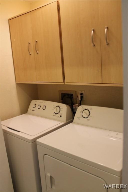 laundry area with independent washer and dryer and cabinet space