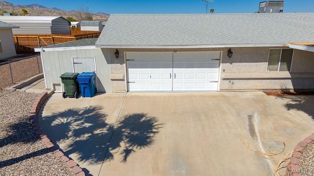 garage with driveway, fence, and a mountain view