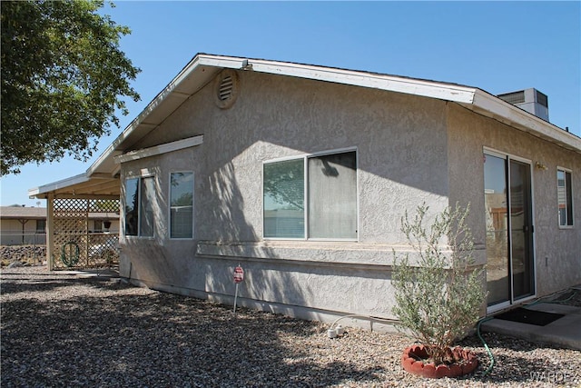 view of property exterior featuring fence and stucco siding