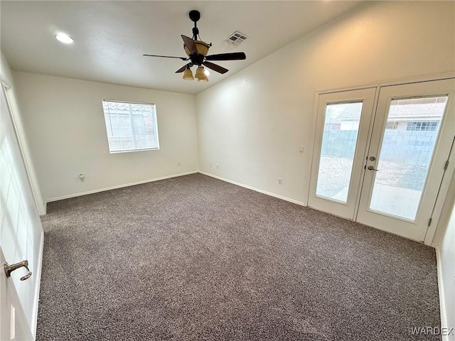 empty room with visible vents, a ceiling fan, lofted ceiling, dark colored carpet, and french doors