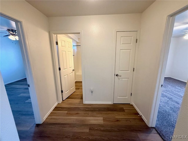 hall with baseboards and dark wood finished floors