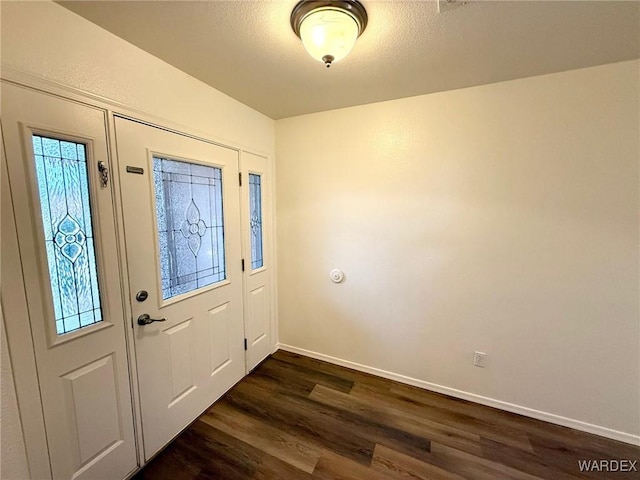 entrance foyer featuring dark wood-style floors, a textured ceiling, and baseboards