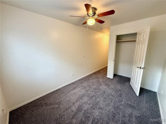 unfurnished bedroom with a ceiling fan, baseboards, dark colored carpet, and a closet