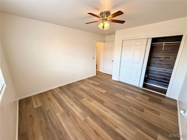 unfurnished bedroom with ceiling fan, a closet, baseboards, and wood finished floors