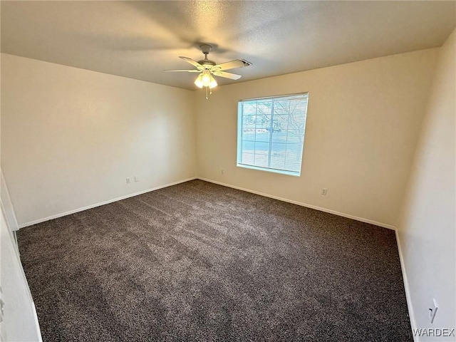 empty room with baseboards, dark colored carpet, and a ceiling fan