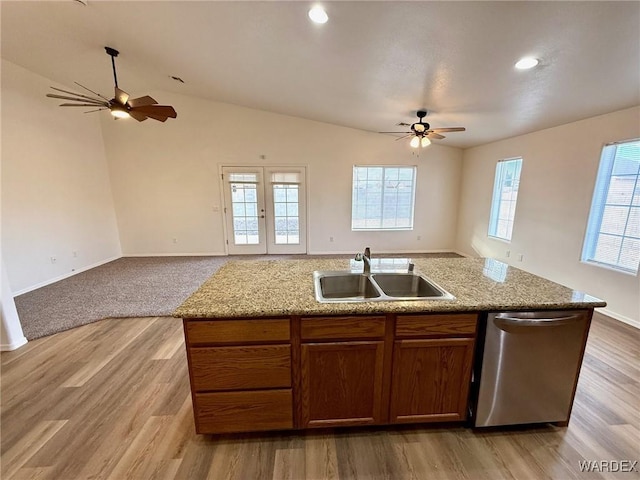 kitchen with a kitchen island with sink, a sink, vaulted ceiling, open floor plan, and dishwasher