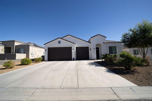 view of front of property featuring concrete driveway, an attached garage, a residential view, and stucco siding