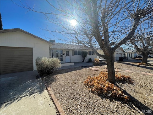 single story home featuring an attached garage, driveway, and stucco siding