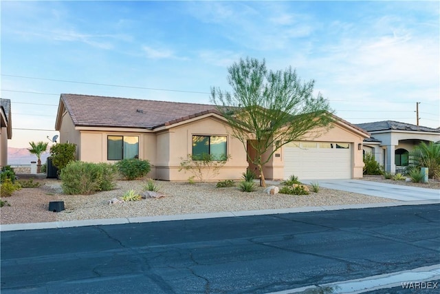 ranch-style house with driveway, a tiled roof, an attached garage, and stucco siding